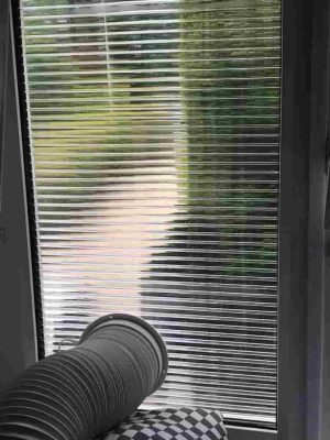 mobile Klimaanlage mit Abluftschlauch durch das Fenster geführt